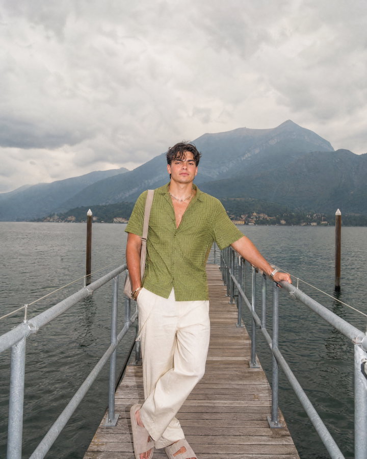 Young Man on Wooden Pier Over Calm Lake