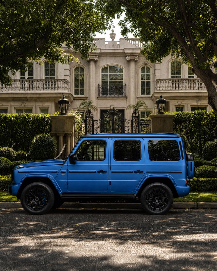 Blue Luxury SUV Beside Elegant Mansion