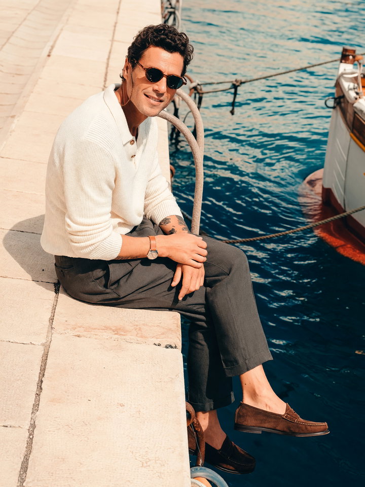 Stylish Young Man on Stone Dock by Harbor