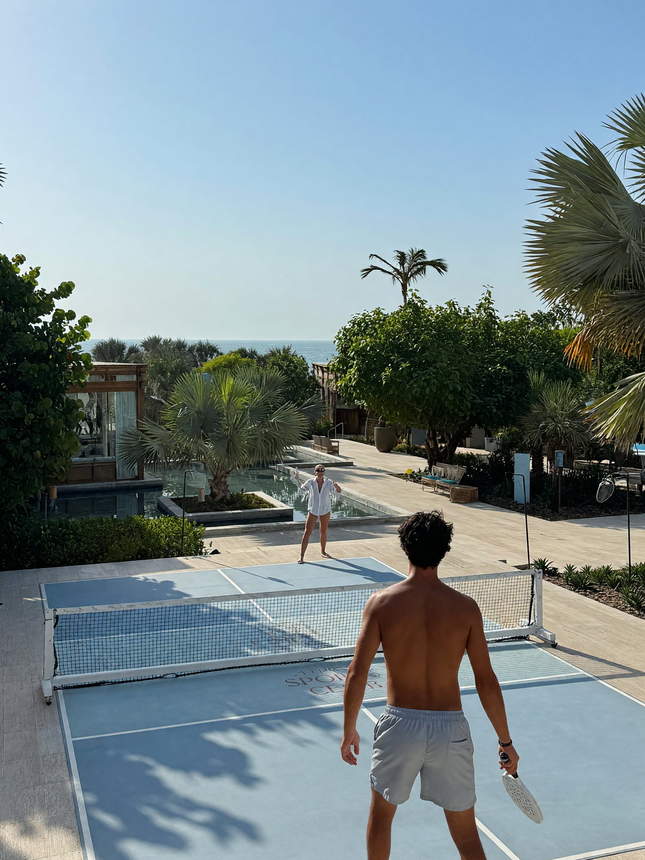 Paddle Tennis Game on Sunny Beachside Court