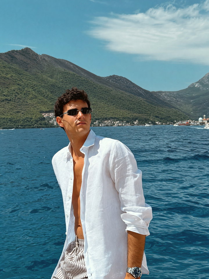 Young Man on Boat with Scenic Mountain Background