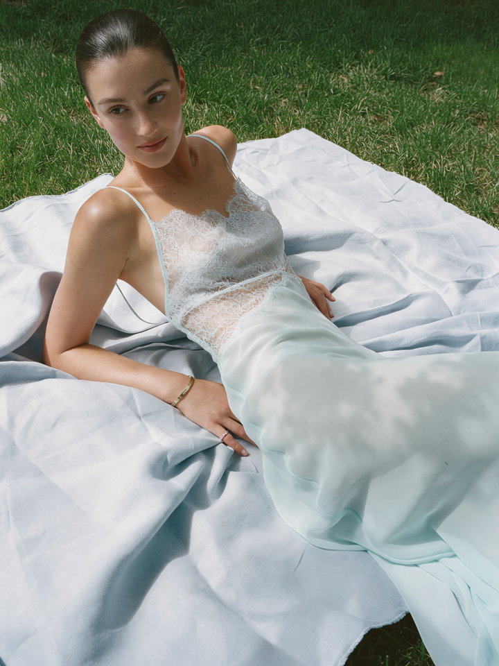Young Woman Reclining on Light Blue Blanket in Grass