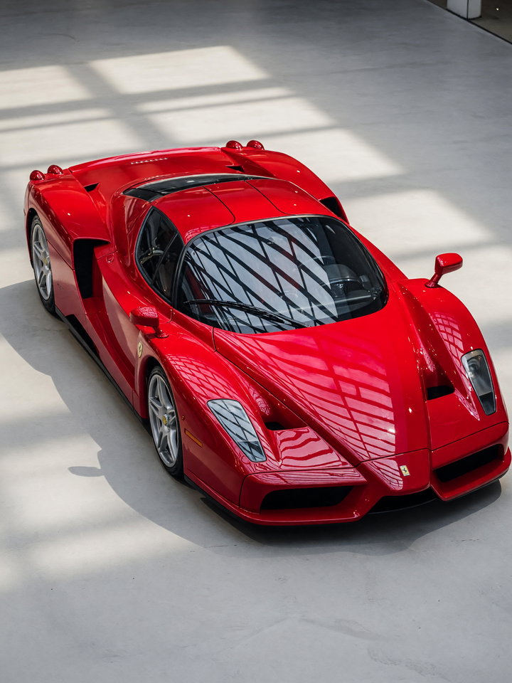 Red Ferrari Enzo and Silver Sports Car on Concrete Floor