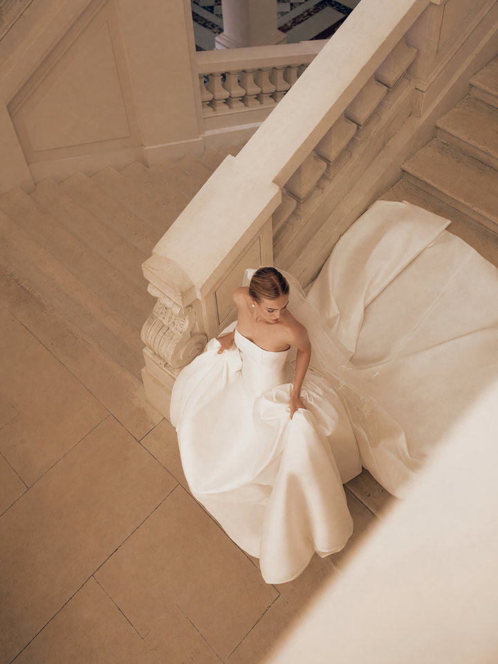 Bride in Elegant White Wedding Gown on Staircase