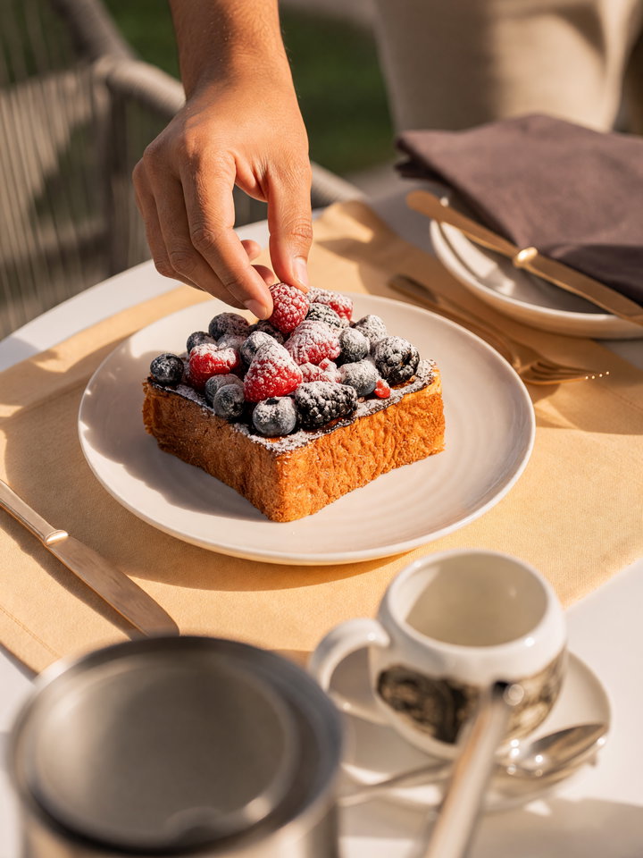 Hand Placing Berries on Toast