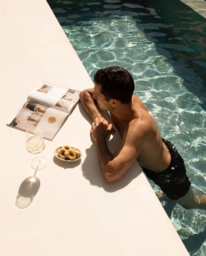 Man Relaxing by Pool with Magazine and Snacks
