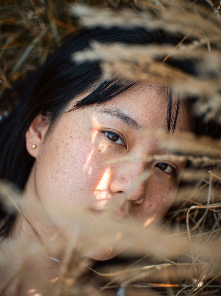 Freckled Woman Lying in Golden Grass