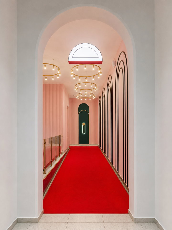 Red Carpeted Hallway with Arched Doorway