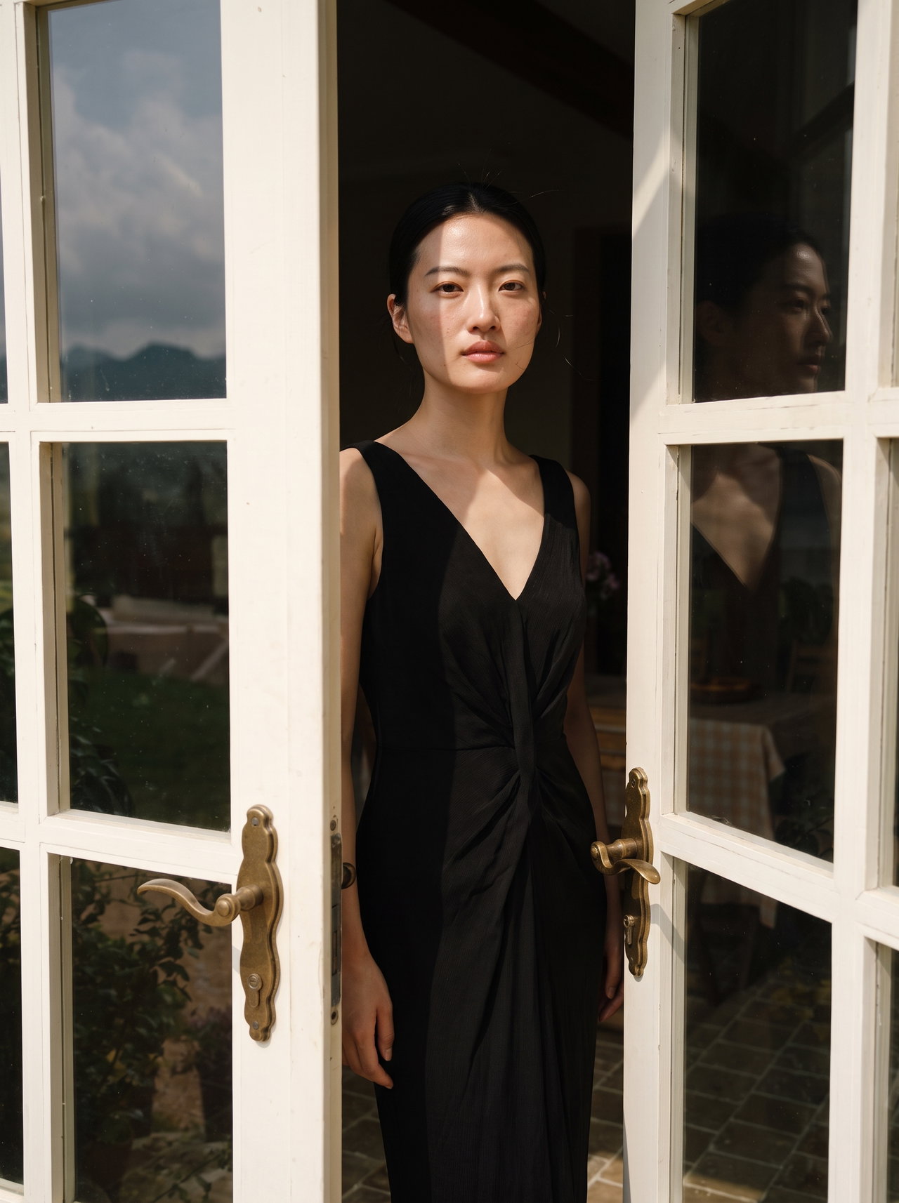 Woman in Black Dress at Open Doorway