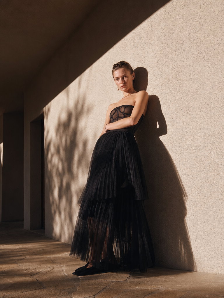 Model in Black Tulle Dress Against Textured Wall
