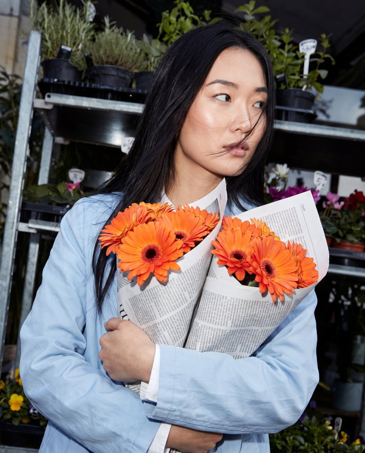 Woman Holding Orange Gerberas in Flower Market