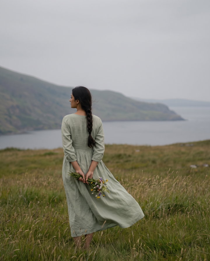 Woman in Sage Linen Dress Holding Wildflowers