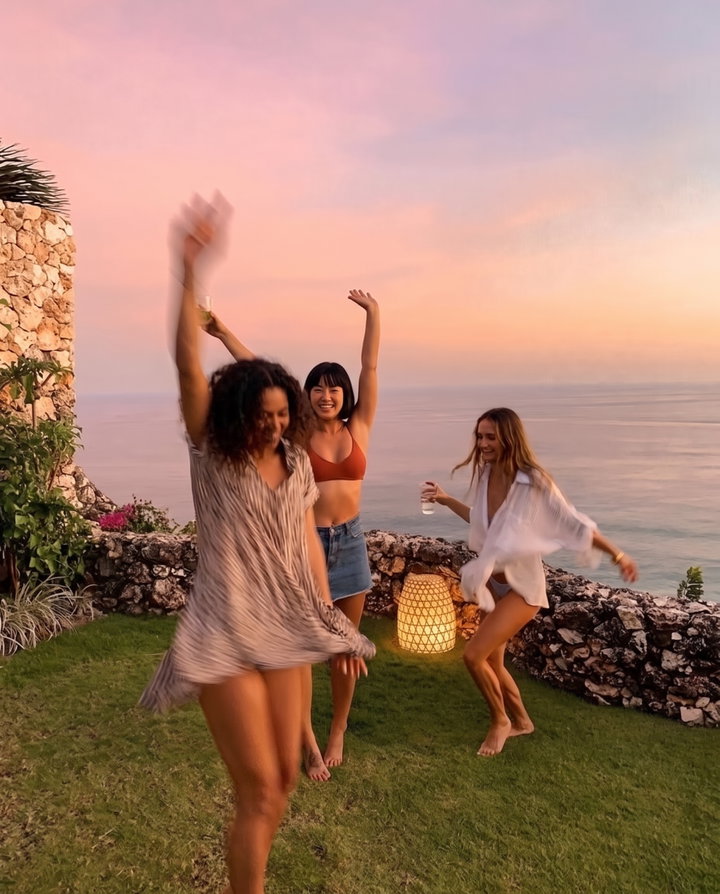 Friends Dancing at Sunset on Clifftop Lawn