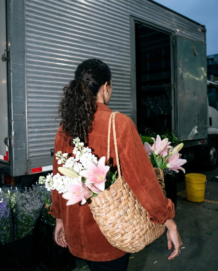 Woman Carrying Flowers in Woven Basket