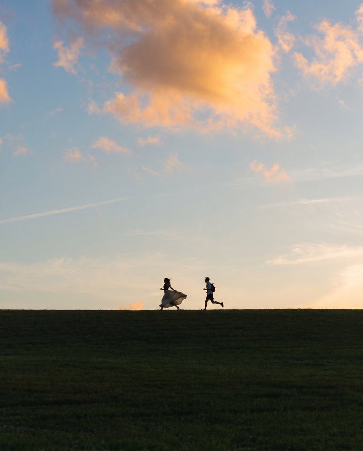 Silhouettes of Friends Running at Sunset