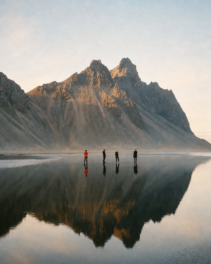 Hikers by Mountain Reflection in Black-Sand Lagoon