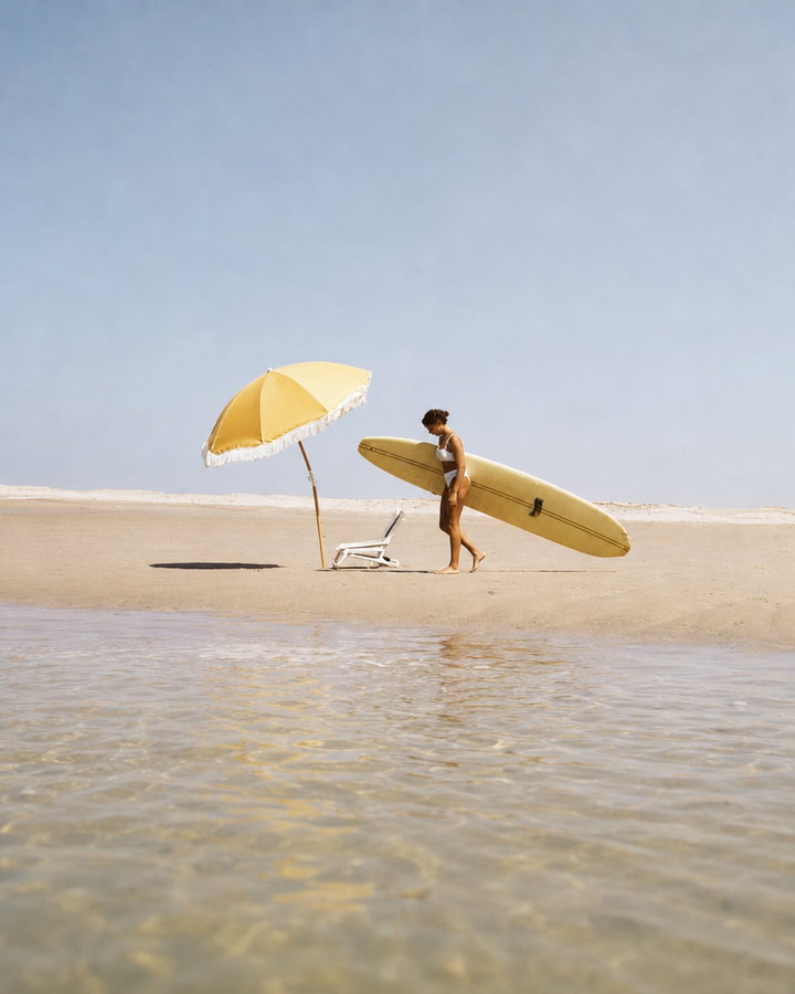 Surfer Walking with Yellow Longboard on Beach