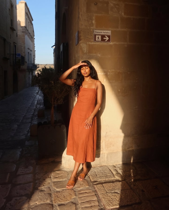 Woman in Rust Linen Dress in Old Town Alley