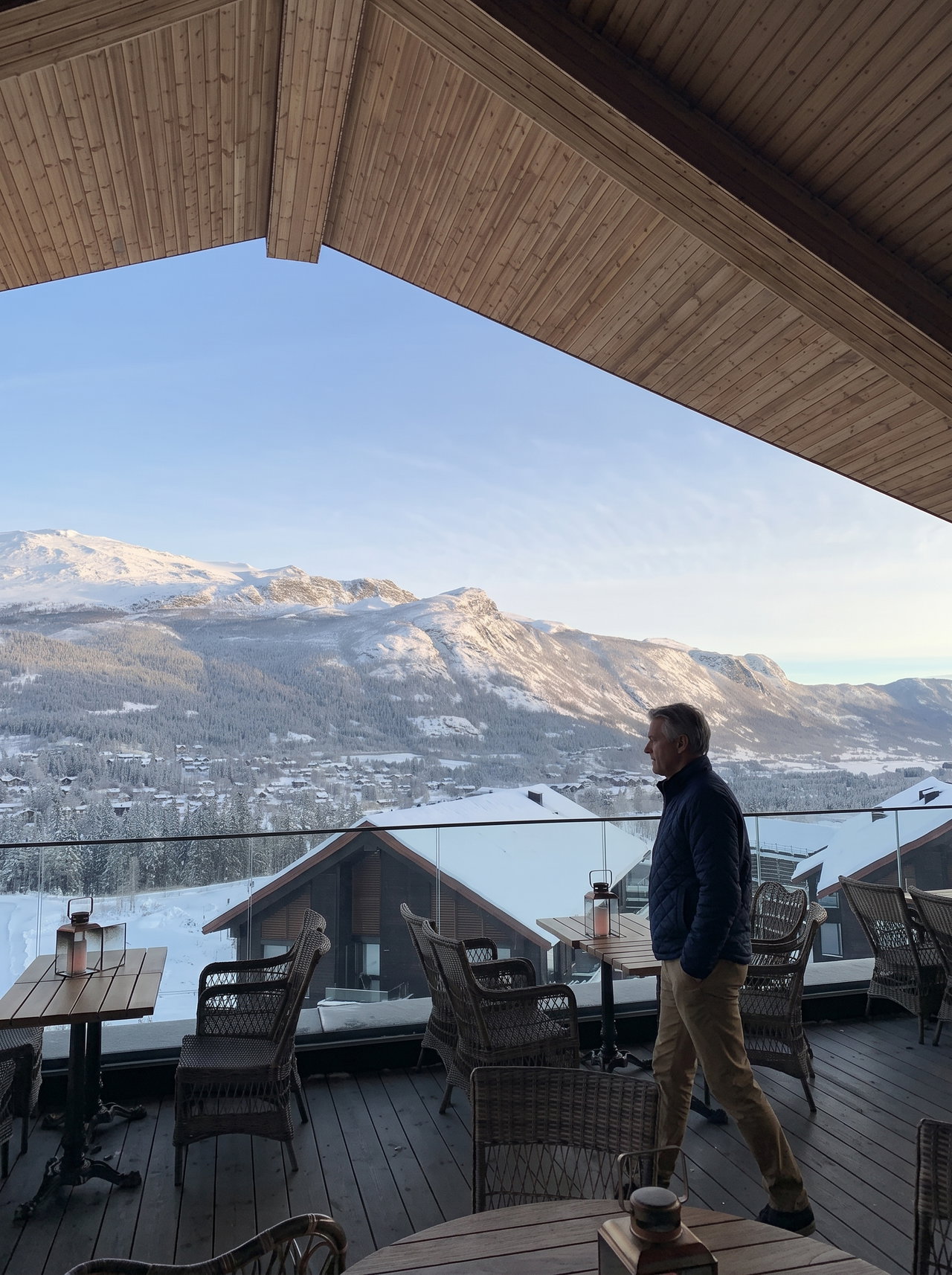 Man Walking on Alpine Terrace Overlooking Snowy Valley
