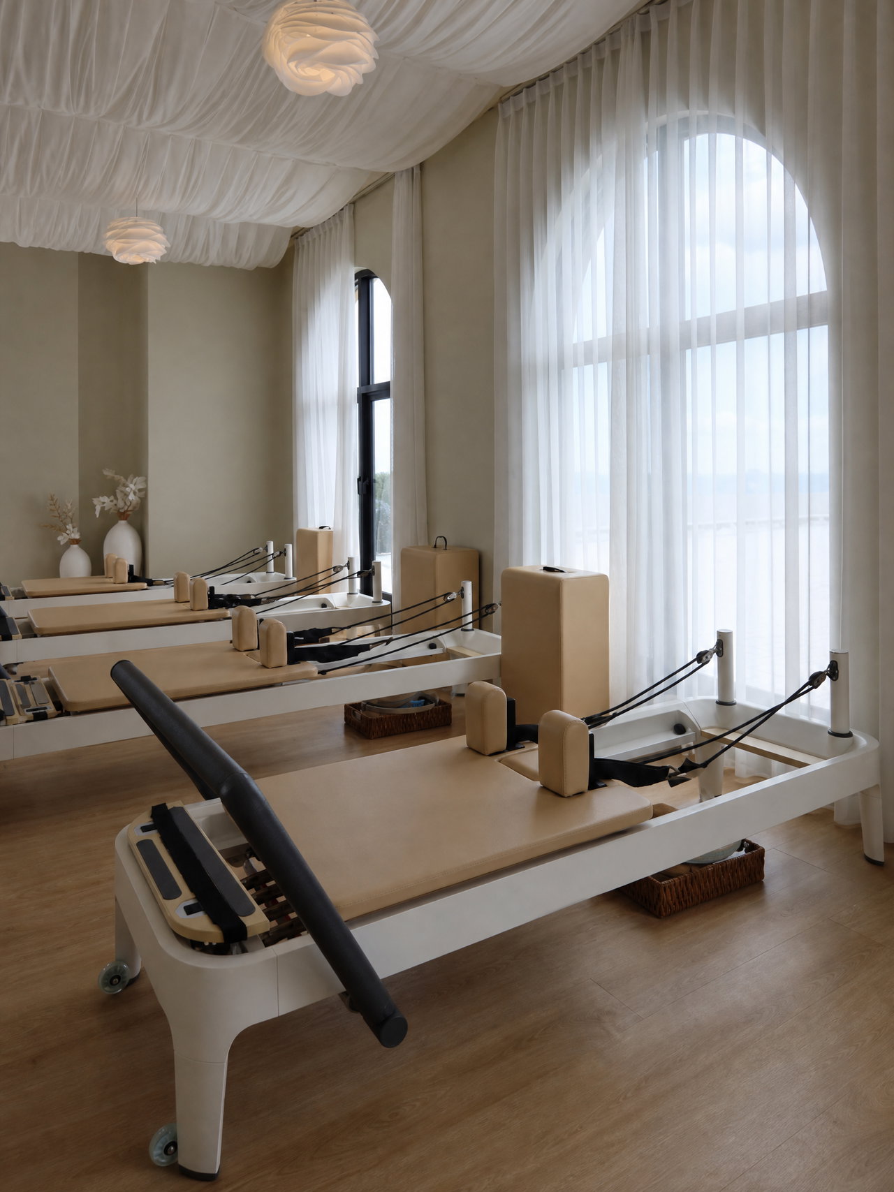 Row of Pilates Reformers by Arched Windows