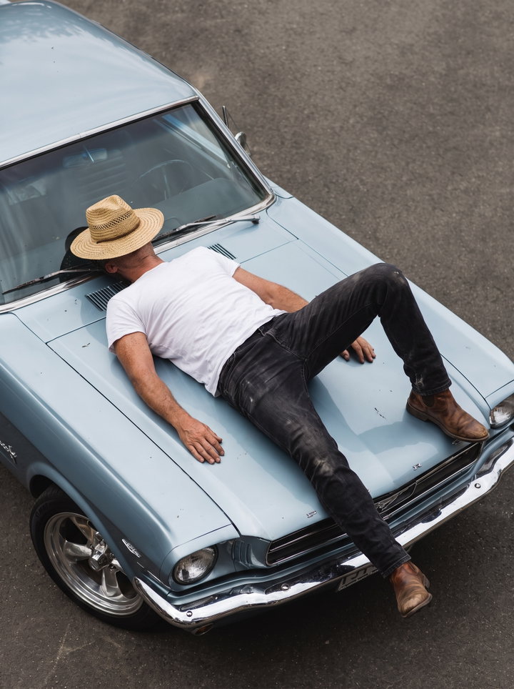 Man Relaxing on Vintage Mustang Hood