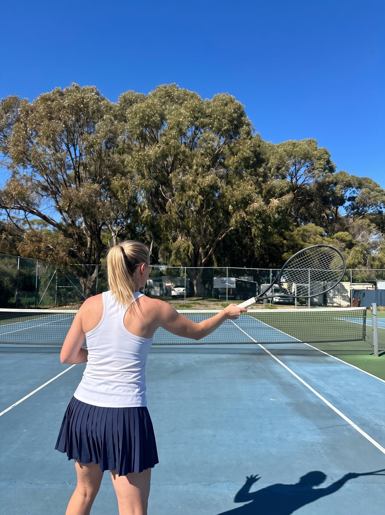 Tennis Player Executing Forehand on Blue Court