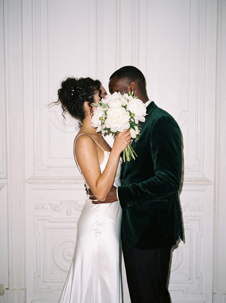 Couple Kissing Behind Bouquet of White Peonies
