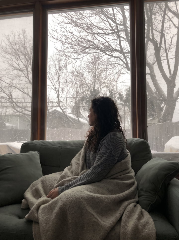 Woman Wrapped in Blanket Watching Winter Trees