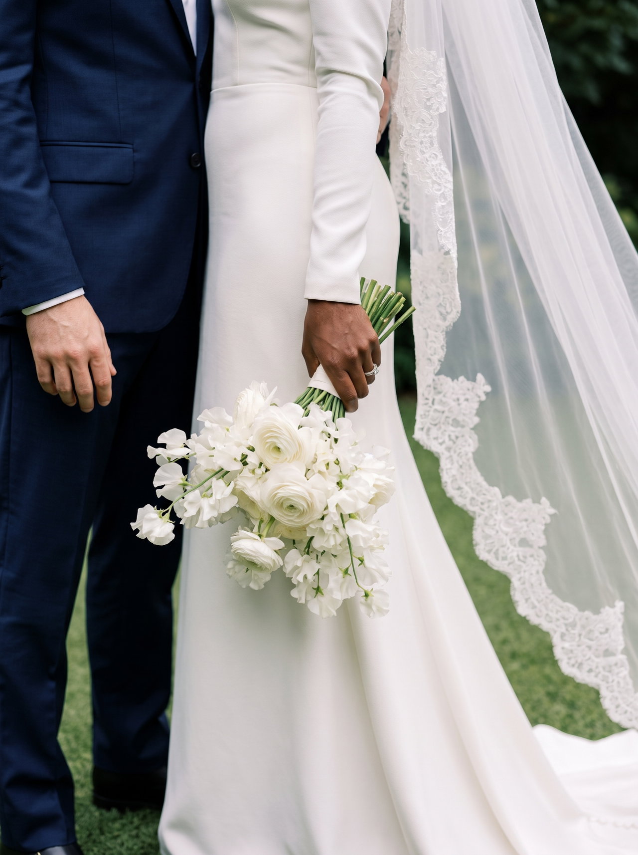 Bride's Hand with White Bouquet in Satin Gown